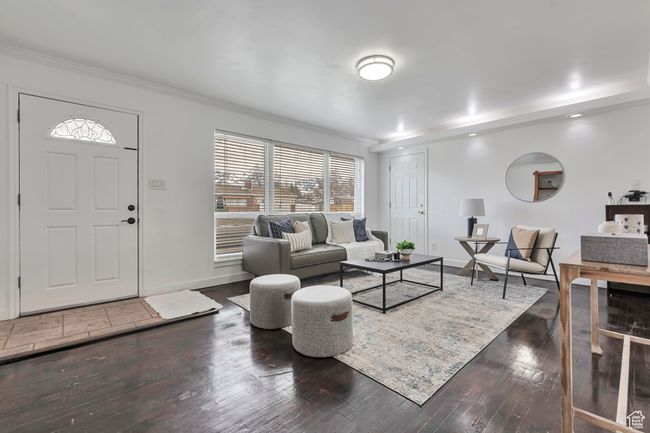Living area featuring ornamental molding, baseboards, and dark wood-style flooring | Image 7