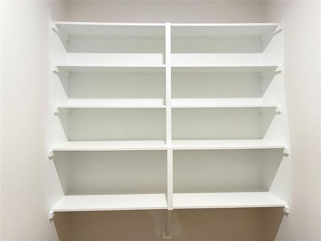 Efficient utility space with built-in shelving for organized storage in utility area. | Image 7