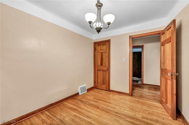 Spare room featuring baseboards, light wood-style floors, and visible vents | Image 10