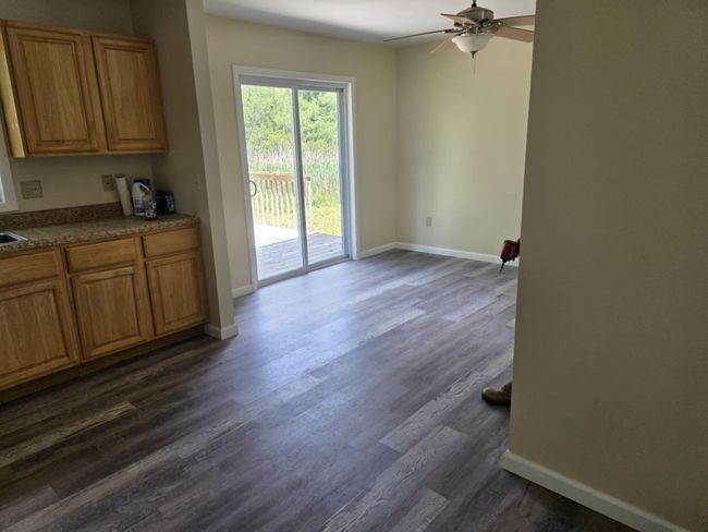 Unfurnished dining area with ceiling fan and dark wood-style floors | Image 12