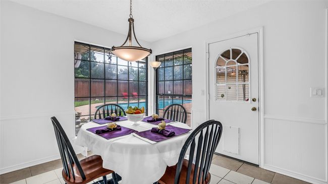 Dining room featuring light tile patterned floors, a decorative wall, healthy amount of natural light, and a wainscoted wall | Image 11