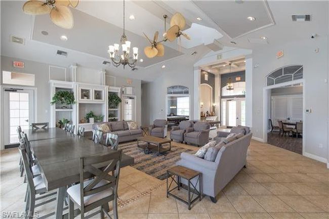 Living room featuring a notable chandelier, a towering ceiling, visible vents, and light tile patterned floors | Image 11