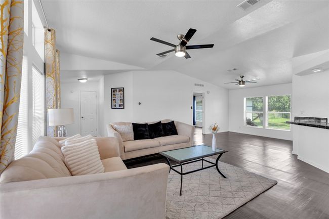 Living area featuring lofted ceiling, ceiling fan, and wood finished floors | Image 4