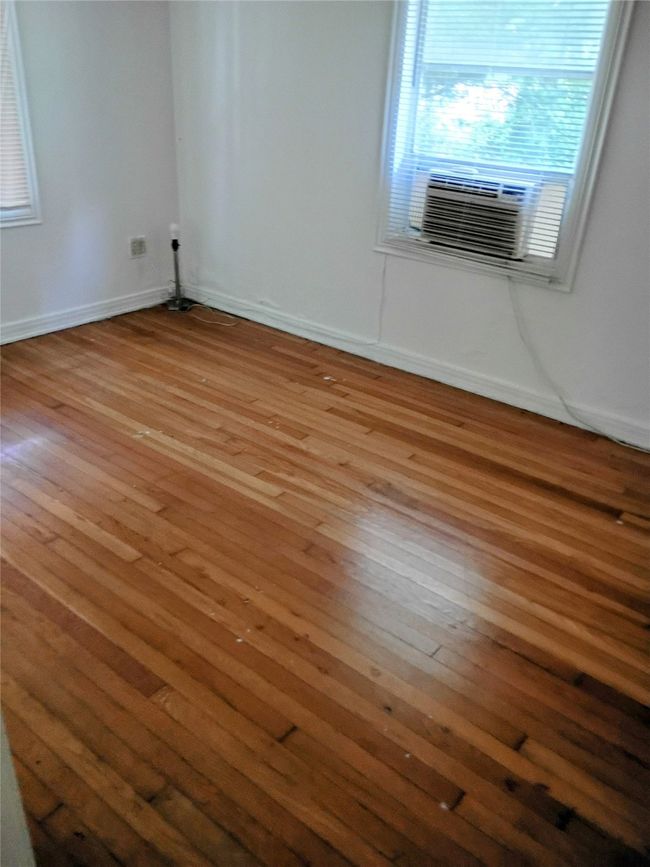 Spare room with hardwood / wood-style flooring, baseboards, and cooling unit | Image 5