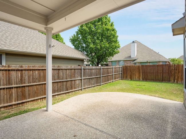 Fenced backyard with a patio | Image 34