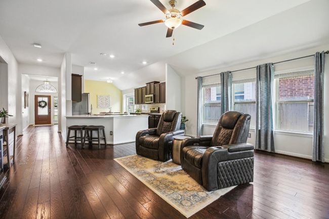 Living area featuring lofted ceiling, baseboards, ceiling fan, and dark wood finished floors | Image 6