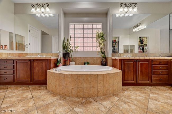 Bathroom featuring vanity, a bath, and tile patterned flooring | Image 33
