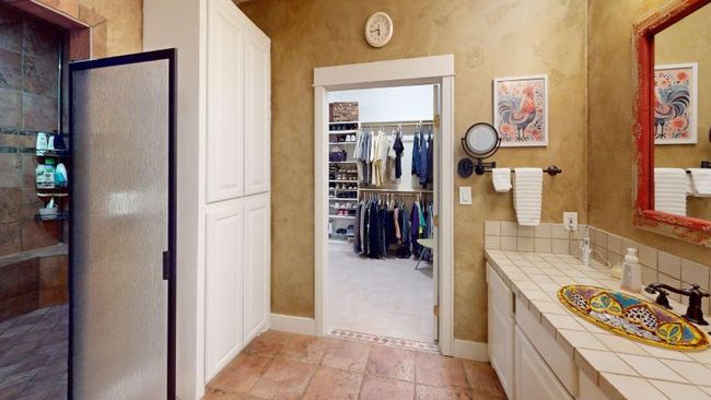 Full master suite bathroom featuring vanity, a walk in closet and a huge walk-in tiled shower. Baths in the main house feature talavera sinks and custom mirrors | Image 14
