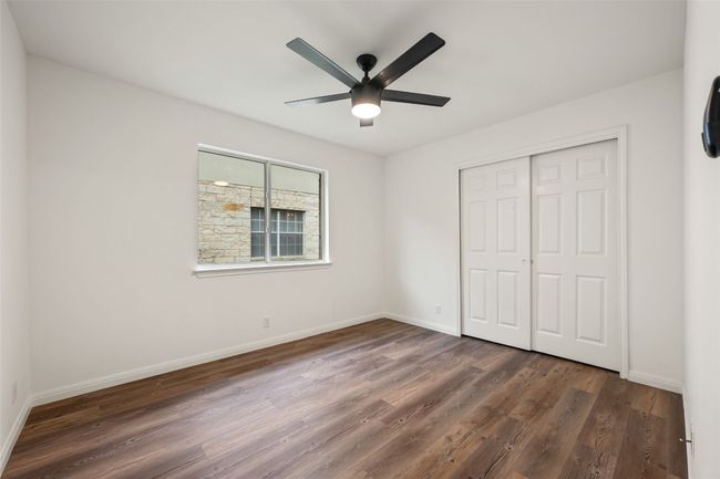 Unfurnished bedroom with dark wood-style flooring, a closet, and ceiling fan | Image 31