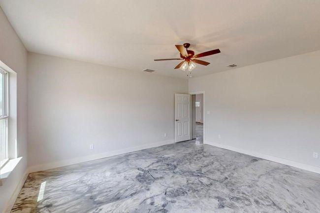 Unfurnished room featuring a ceiling fan, visible vents, and plenty of natural light | Image 17