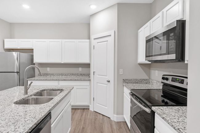 Kitchen featuring appliances with stainless steel finishes, a sink, light wood-style floors, white cabinets, and recessed lighting | Image 14