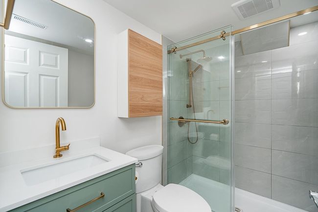 Bathroom featuring toilet, vanity, a shower stall, and visible vents | Image 25