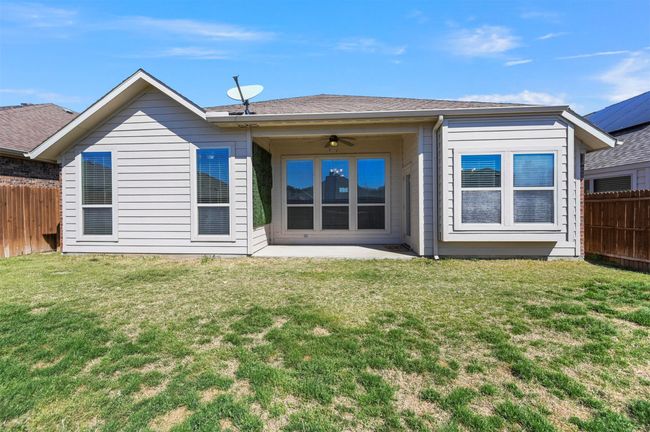 Back of property featuring a fenced backyard, a patio area, a yard, and a ceiling fan | Image 37