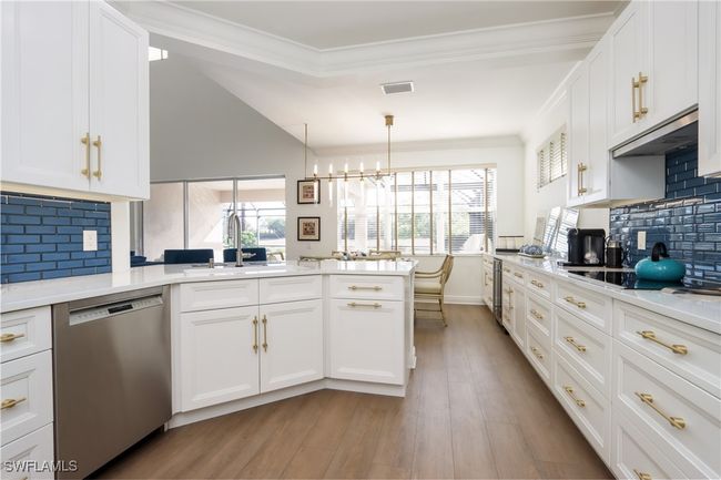 Kitchen with dishwasher, ventilation hood, a peninsula, light wood-style flooring, and white cabinets | Image 8