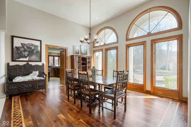dining space featuring a chandelier, a towering ceiling, and wood finished floors | Image 13