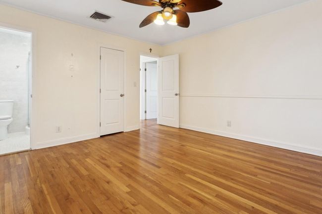 Laundry room with stacked washer and clothes dryer and light wood-style flooring | Image 24
