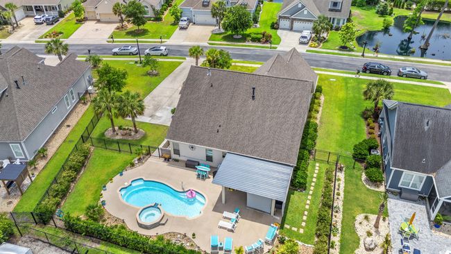 Aerial view of residential area featuring a pool and a nearby body of water | Image 36