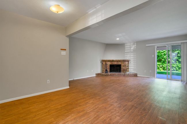 Unfurnished living room featuring finished floors and a fireplace | Image 8