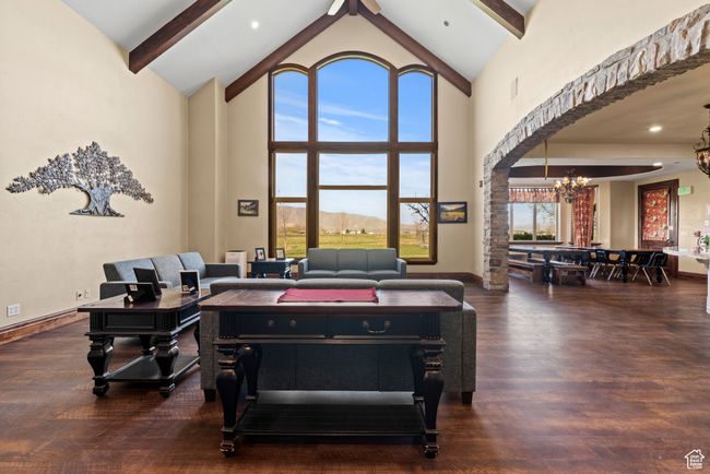 Playroom with beamed ceiling, high vaulted ceiling, wood finished floors, baseboards, and a notable chandelier | Image 25