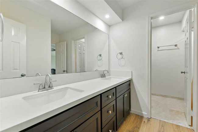 The upstairs full bathroom shared between the fourth and fifth bedroom features vinyl plank (2016) and tile floors, double sinks, an updated vanity and a tub+shower duo. | Image 29