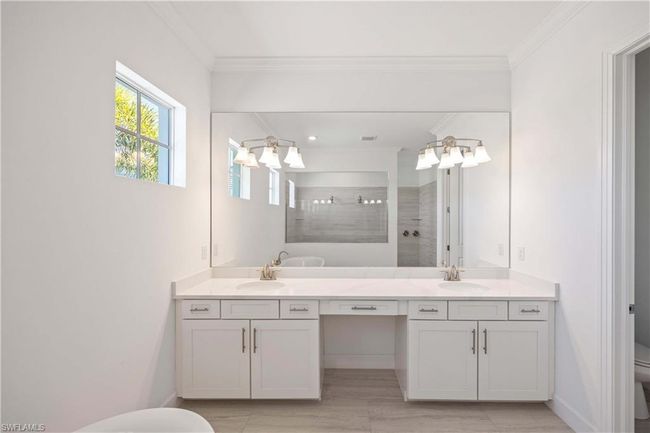 Full bathroom featuring a notable chandelier, toilet, ornamental molding, and walk in shower | Image 17