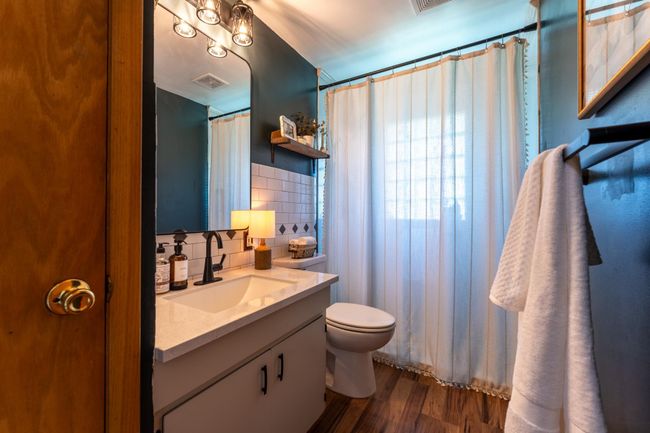 Main level 3/4 bathroom updated with fresh paint, new shower head, sink faucet, light fixture & mirror. | Image 15
