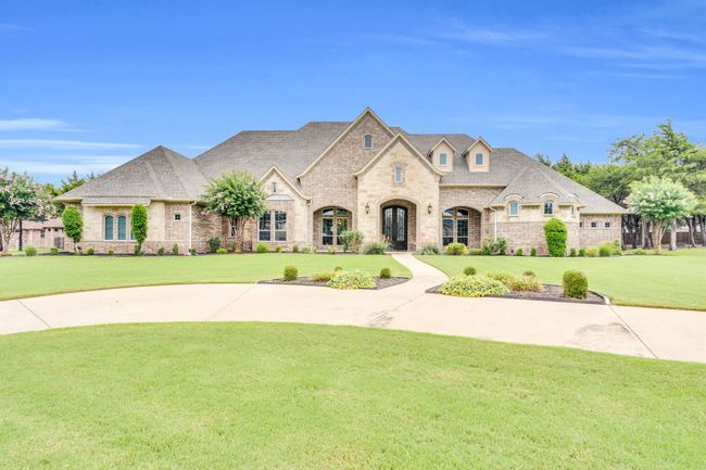 French country inspired facade with a front yard, stone siding, and roof with shingles | Image 4