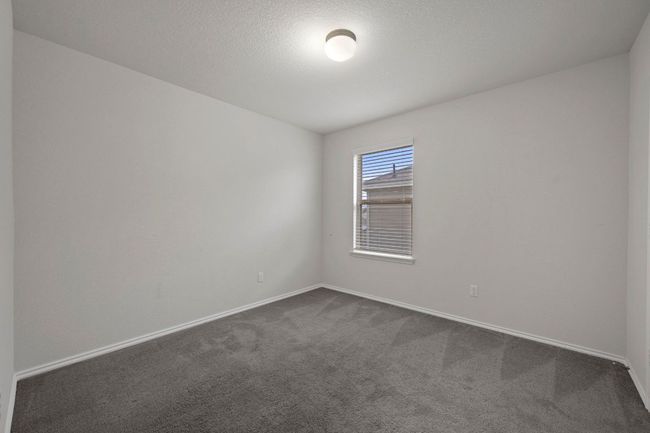 Unfurnished room featuring baseboards, a textured ceiling, and dark colored carpet | Image 17