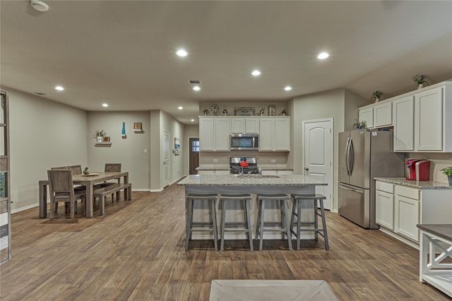 The island kitchen offers ample seating while entertaining and the crisp white cabinetry keeps the space light and bright. | Image 21