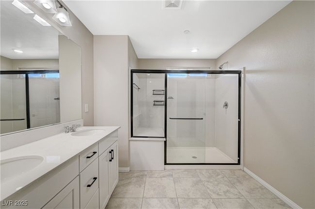Bathroom with double vanity, baseboards, and a stall shower | Image 42