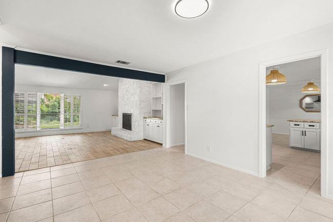 Unfurnished living room featuring a fireplace and light tile patterned floors | Image 10
