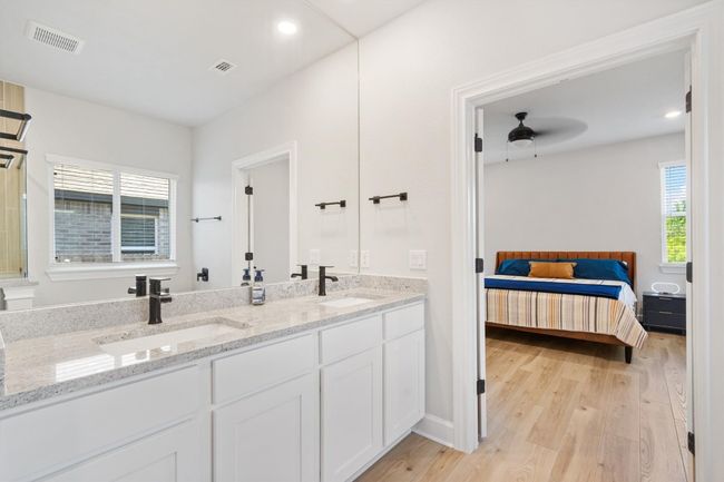 Ensuite bathroom featuring wood finished floors, a ceiling fan, double vanity, and recessed lighting | Image 13