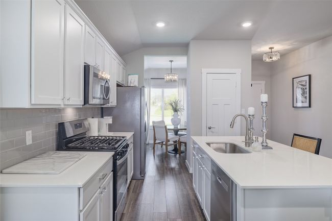 Kitchen featuring appliances with stainless steel finishes and a breakfast bar | Image 11