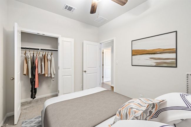 Carpeted bedroom featuring baseboards, visible vents, a closet, and ceiling fan | Image 18