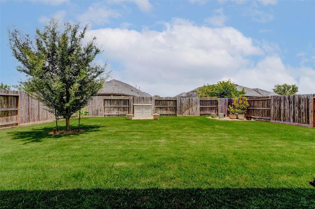 A mature tree graces the backyard, offering shade and privacy. This versatile outdoor space invites endless possibilities for relaxation and enjoyment. | Image 27