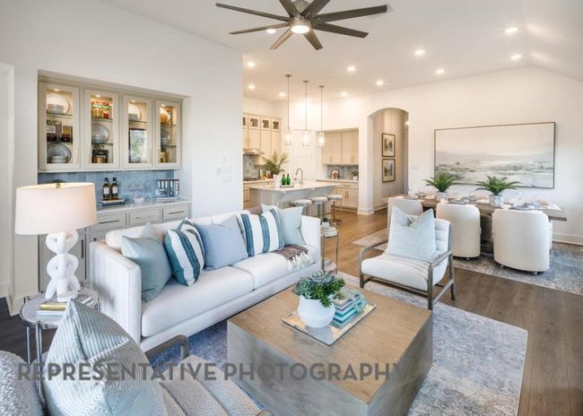 Living area featuring a ceiling fan, arched walkways, wood finished floors, vaulted ceiling, and recessed lighting | Image 11
