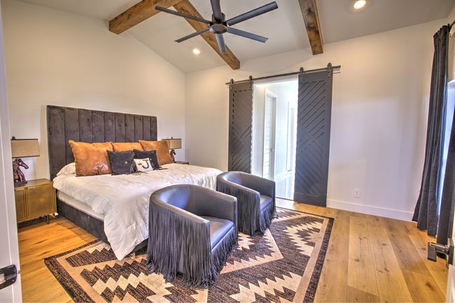 Bedroom featuring vaulted ceiling with beams, baseboards, a barn door, recessed lighting, and hardwood / wood-style flooring | Image 19