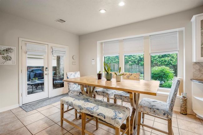 Double glass doors offer natural light and easy access to the covered backyard patio, also on offer are three large windows. | Image 15