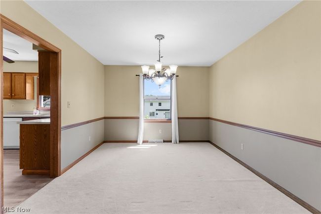 Empty room featuring an inviting chandelier and light carpet | Image 9