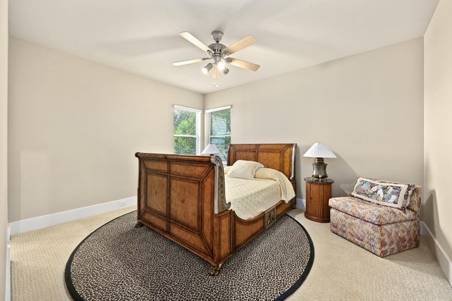 Bedroom with light colored carpet, baseboards, and ceiling fan | Image 19