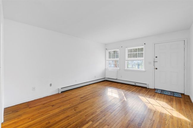 Entryway featuring a baseboard heating unit, hardwood / wood-style floors, and baseboards | Image 6