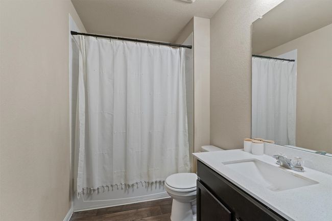Bathroom featuring wood finished floors, vanity, and shower / bath combo with shower curtain | Image 21
