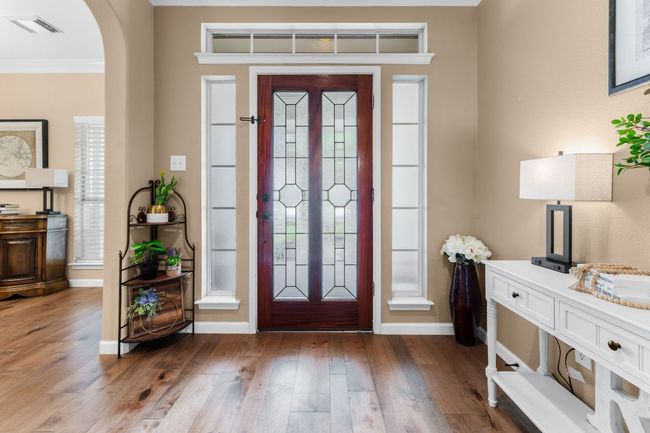 Foyer entrance with arched walkways, crown molding, wood finished floors, and baseboards | Image 4
