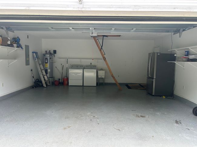 Garage with water heater, electric panel, freestanding refrigerator, washer and dryer, and a sink | Image 8