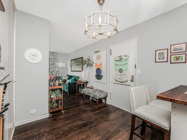 Dining area with wood finished floors and a chandelier | Image 7