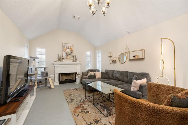 The living room features a wood-burning fireplace, soaring ceilings, and generous space for relaxing or gathering—ready to shape into the heart of the home. | Image 10