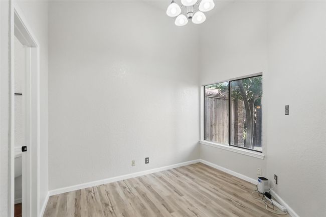 Spare room featuring a chandelier, LVT, baseboards, and high vaulted ceiling | Image 16