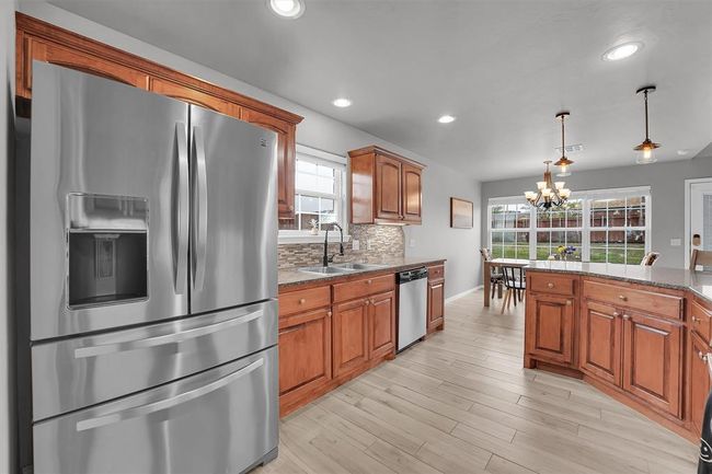 Kitchen With Quartz counter-tops and backsplash, stainless steel refrigerator | Image 12