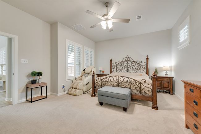 Bedroom featuring a ceiling fan, visible vents, and light colored carpet | Image 16