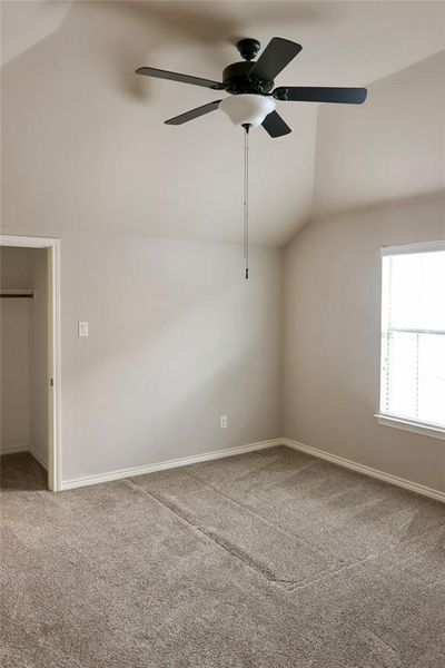 Unfurnished room with carpet floors, ceiling fan, and vaulted ceiling | Image 1